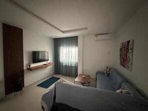 a living room with a couch and a television at Appart Yassou in Dar Salah Bey +5 photos