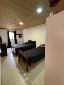 two beds in a room with wooden ceilings at Departamento norte interno in Rafaela