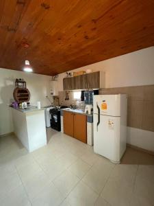 a kitchen with a white refrigerator and a wooden ceiling at Departamento norte interno in Rafaela