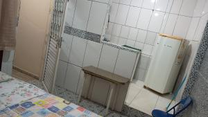 a small kitchen with a bench and a refrigerator at Pousada do Jackson in São Thomé das Letras +45 photos