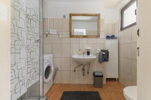 a bathroom with a sink and a washing machine at Apartments on island Molat next to the sea - by TA Leut Agency in Brgulje +36 photos