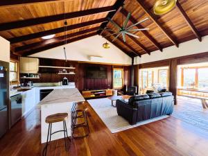 a kitchen and living room with a couch and a table at Christophers Cottage in Bilpin