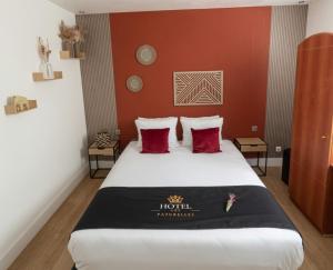 a hotel room with a bed with red walls at Hôtel les Paturelles in Avesnelles
