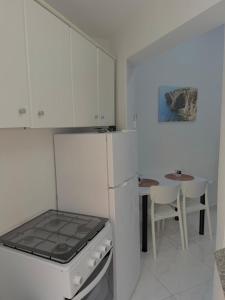 a kitchen with a stove top oven next to a table at One bedroom apartment in Marsaskala