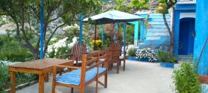 a table and chairs with an umbrella on a patio at panorama view in Chefchaouen