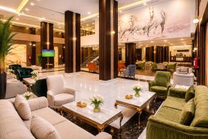 a hotel lobby with couches and tables and chairs at TULIP PLAZA - By Le Park Concord in Hafr Al-Batin