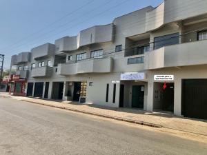 a large white building on the side of a street at Lindo Apto102 em Primavera do Leste in Primavera do Leste