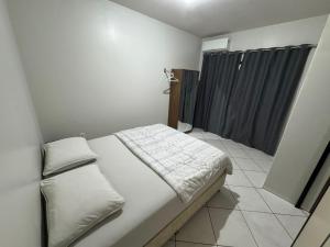 a small bedroom with a bed and a shower at Lindo Apto102 em Primavera do Leste in Primavera do Leste