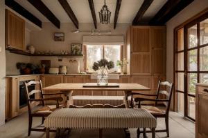 a kitchen with a wooden table and chairs and a table at Harvest Cottage Blue Mountains in Leura