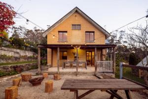 a house with a picnic table in front of it at Harvest Cottage Blue Mountains in Leura +41 photos