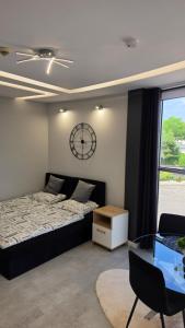 ein Schlafzimmer mit einem Bett und einer Uhr an der Wand in der Unterkunft Anpol Udany Wypoczynek in Inowrocław