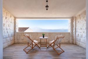 a table and chairs in a room with a window at Rezevici Horison View Apartment in Reževići