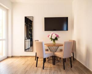 a dining room with a table and chairs with a vase of flowers at Rezevici Horison View Apartment in Reževići +4 photos