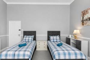 two beds sitting next to each other in a bedroom at Spacious two bedroom flat in Lansdowne in Bournemouth
