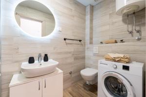 a bathroom with a sink and a washing machine at Rezevici Horison View Apartment in Reževići