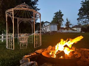 a fire pit in a yard with a gazebo at La Măgaru Tăvălit in Nucşoara