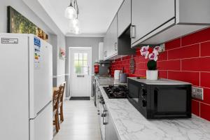 a kitchen with red tiles and a black appliance at Spacious two bedroom flat in Lansdowne in Bournemouth