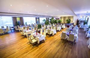 a dining room with white tables and chairs at Marshal Garden Hotel in Bucharest