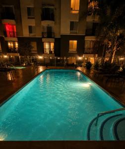a large swimming pool in front of a building at night at Ocean Breeze Stay Near Airport LAX & Stadium in Los Angeles