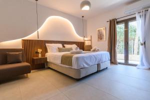a bedroom with a large bed and a chair at LemonTree Villa Rooftop Jacuzzi And Sea Views in Skopelos Town