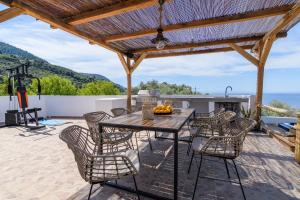 a patio with a table and chairs and a grill at LemonTree Villa Rooftop Jacuzzi And Sea Views in Skopelos Town
