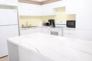 a white kitchen with white appliances and a white counter top at crown y key in Ciales +20 photos