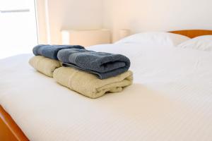 a pile of towels sitting on top of a bed at Grand Holiday Residence in Komarna +228 photos