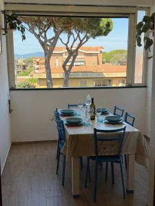 una sala da pranzo con tavolo e sedie e una grande finestra di Giusti Mare a Grosseto