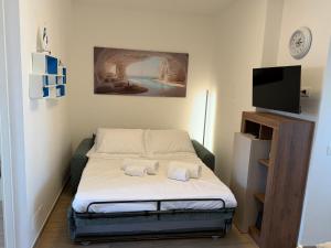 una piccola stanza con un letto e una TV a schermo piatto di Giusti Mare a Grosseto