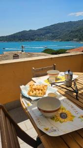 a table with food and a view of the ocean at Ampia casa marinara con meravigliosa terrazza vista mare Da Mario e Rosanna in Portovenere