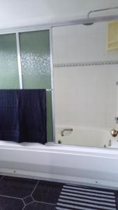a bathroom with a bath tub with blue towels at Flat - Condomínio Summerville Apart in Miguel Pereira