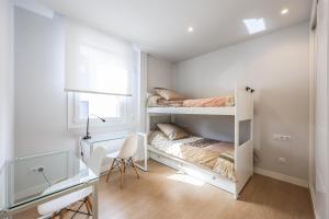 a bedroom with two bunk beds and a desk at Spacious Home with Private Garden and Parking in Madrid