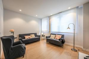 a living room with two couches and two chairs at Spacious Home with Private Garden and Parking in Madrid