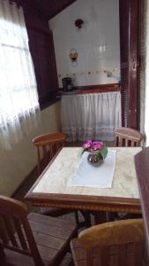 a dining room table with a vase of flowers on it at Flat - Condomínio Summerville Apart in Miguel Pereira