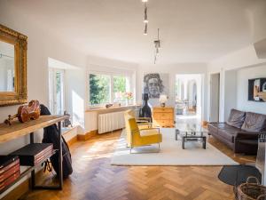 a living room with a yellow chair and a couch at Villa Stradivari - Black Forest with Alpine views in Lenzkirch