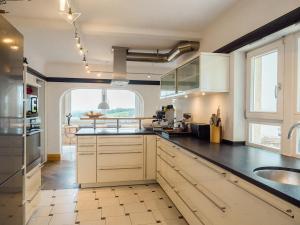 a kitchen with white cabinets and a large window at Villa Stradivari - Black Forest with Alpine views in Lenzkirch
