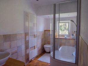 a bathroom with a tub and a toilet and a sink at Villa Stradivari - Black Forest with Alpine views in Lenzkirch +24 photos