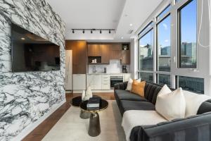 a living room with a couch and a table at NoMad Suites - Toronto's Entertainment District in Toronto
