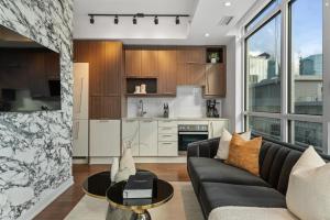 a living room with a couch and a table at NoMad Suites - Toronto's Entertainment District in Toronto