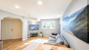 a living room with a couch and a painting on the wall at Bright & Cozy Private 1BR Suite in Whitehorse
