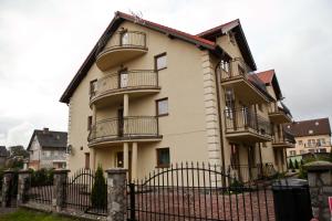 un edificio de apartamentos con balcones y una valla en Apartamenty by Hanna, en Łeba