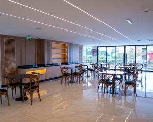 a dining room with tables and chairs and windows at Il Divo Boutique Hotel in Ciudad del Este