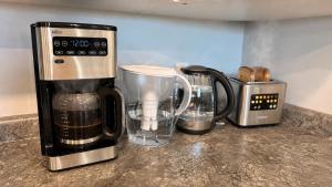 a kitchen counter with a coffeemaker and a coffee maker at Bright & Cozy Private 1BR Suite in Whitehorse