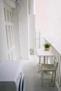 a white balcony with a table and a table and chair at Corinth Central Studio in Korinthos