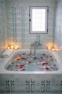 a bathroom with a tub with flowers in it at Corinth Central Studio in Korinthos +12 photos