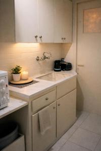 a kitchen with a sink and a microwave at Corinth Central Studio in Korinthos