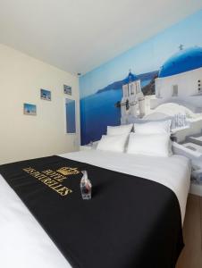 a large white bed with a black blanket on it at Hôtel les Paturelles in Avesnelles +46 photos