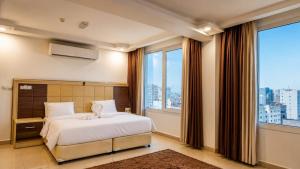 a bedroom with a bed and a large window at Diamond Star Hotel فندق النجمة الماسية in Seeb +58 photos