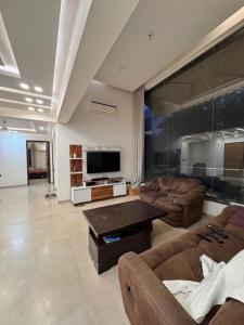 ein Wohnzimmer mit zwei Sofas und einem Flachbildfernseher in der Unterkunft Kingswick in Kathmandu