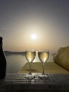 two glasses of white wine sitting on a table at Esmi Suites Santorini in Imerovigli